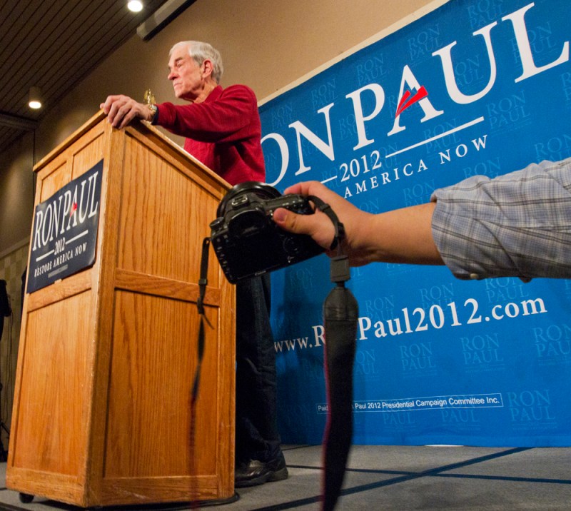 A photographer reacers past the ropes for a closer shot.