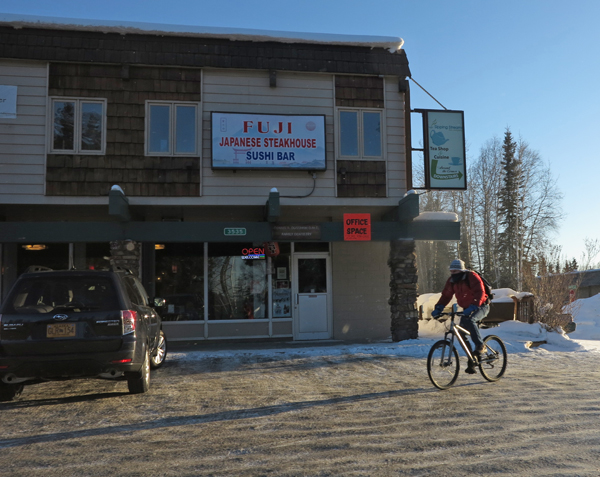 A winter biker casts a long shadow outside Corner Campus Mall, March 13, 2013.