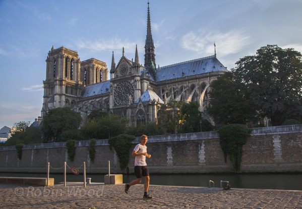 A jogger makes his way along the Seine River with Notre-Dame Cathedral in the background, July 8, 2013.