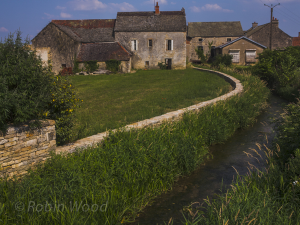 This brick house comes complete with a creek. 